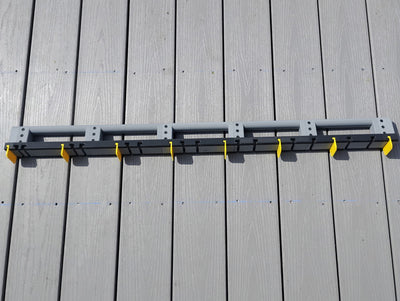 DIY builder installing decking using the Deck Board Spacer to hold spacing between boards without assistance
